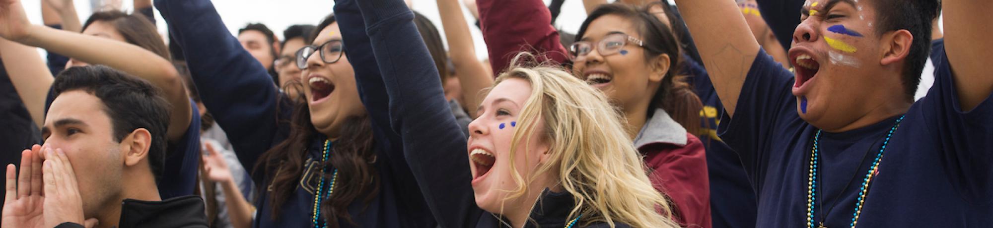 Group of UC Davis students yelling at homecoming